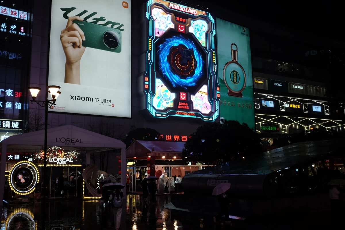 Sztuczna inteligencja w reklamie: gdzie pomaga, a gdzie nadal trzeba człowieka Nocna ulica w mieście z podświetlonymi neonami i billboardami