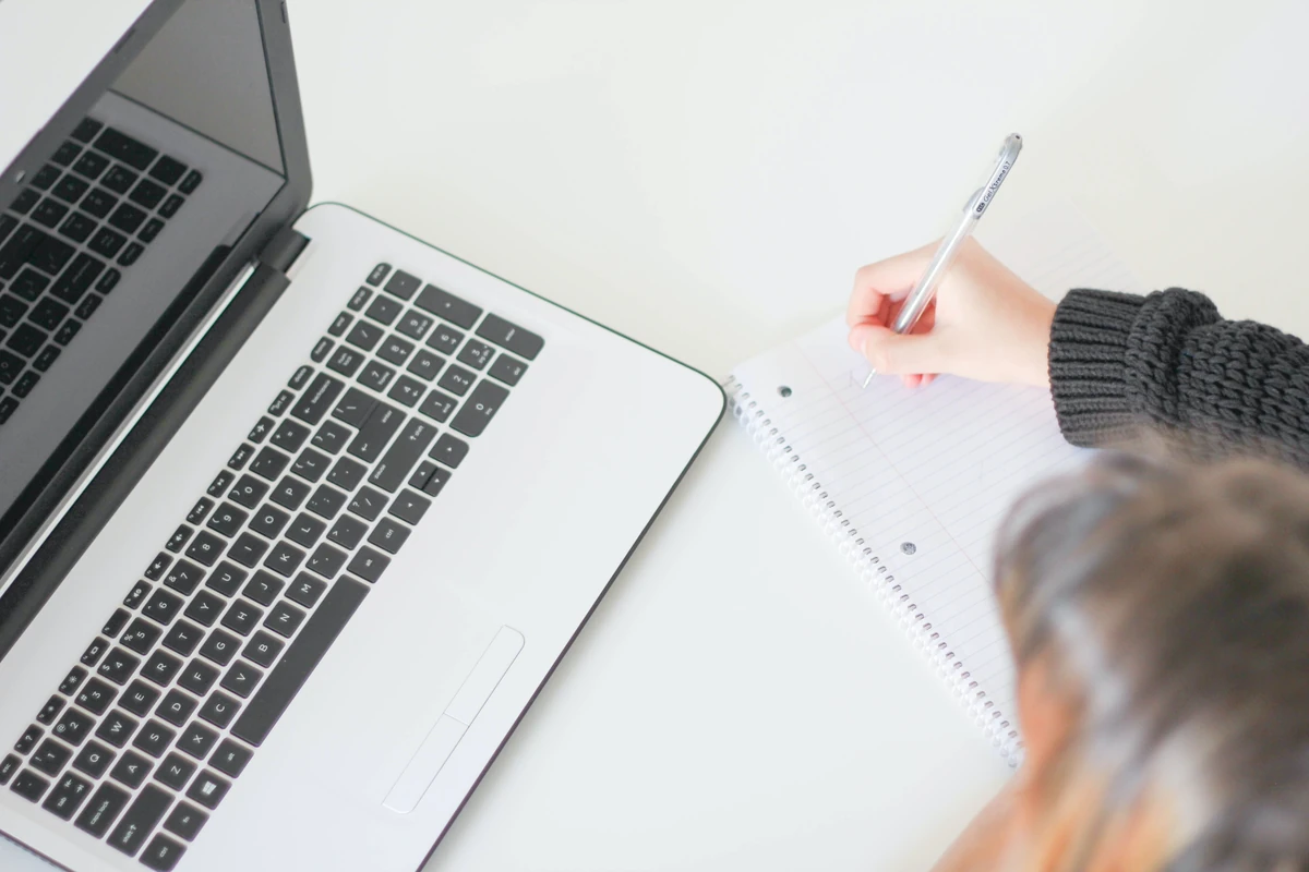 Przyszłość copywritingu w dobie AI: co zmieni się dla copywriterów? Domowe stanowisko pracy z laptopem i notesem