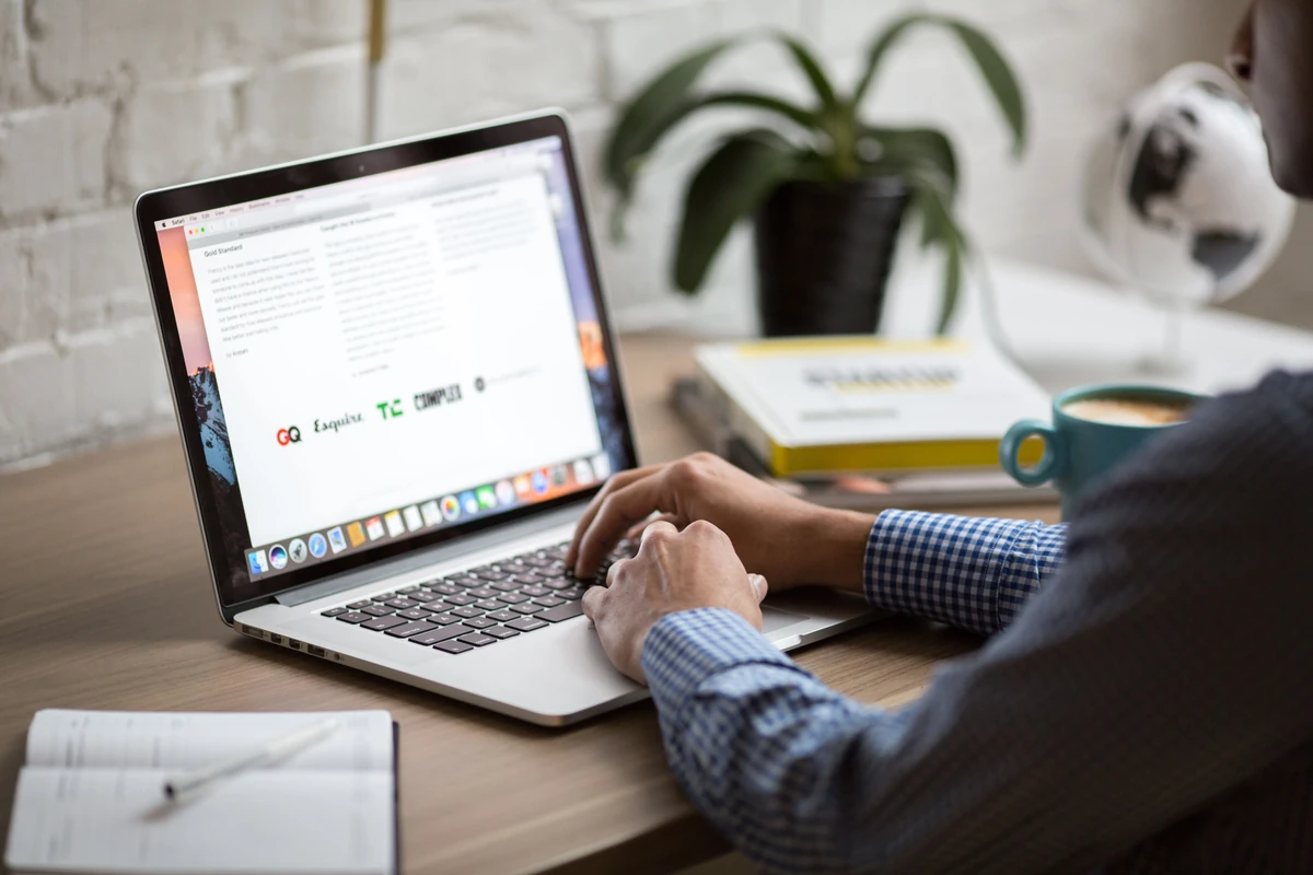 Google Search Console: jak aktualizować stare wpisy blogowe na podstawie danych Mężczyzna pracuje na laptopie przy biurku z kawą