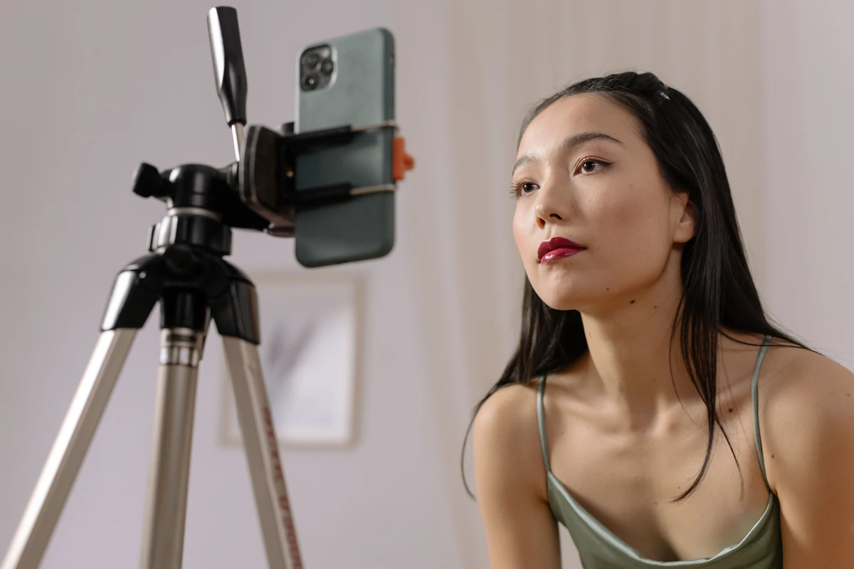 Influencerzy i social media a widoczność w Google: co naprawdę działa? Kobieta nagrywa vloga w domu smartfonem na statywie