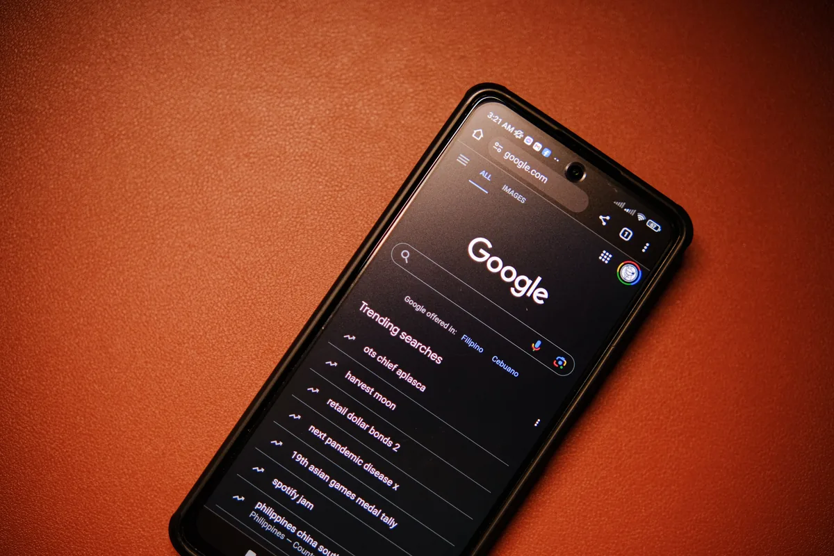 Czynniki rankingowe Google: co realnie wpływa na pozycje w SEO? Smartfon z otwartą wyszukiwarką Google leżący na stole w nocy
