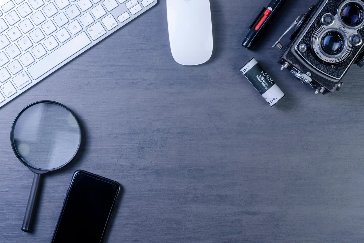 Google Ads dla firmy: jak zacząć reklamę bez przepalania budżetu Biurko z aparatem, klawiaturą, lupą i smartfonem