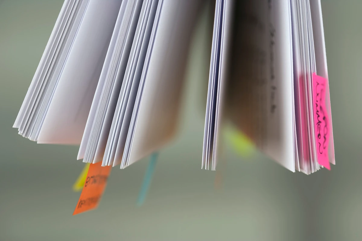 Optymalizacja treści pod wyszukiwanie głosowe: jak pisać naturalne odpowiedzi Zbliżenie na strony książki z kolorowymi zakładkami