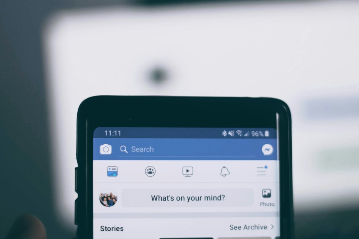 Telefon z otwartą aplikacją Facebook i polem tworzenia nowego posta, ilustracja limitu linków dla stron firm
